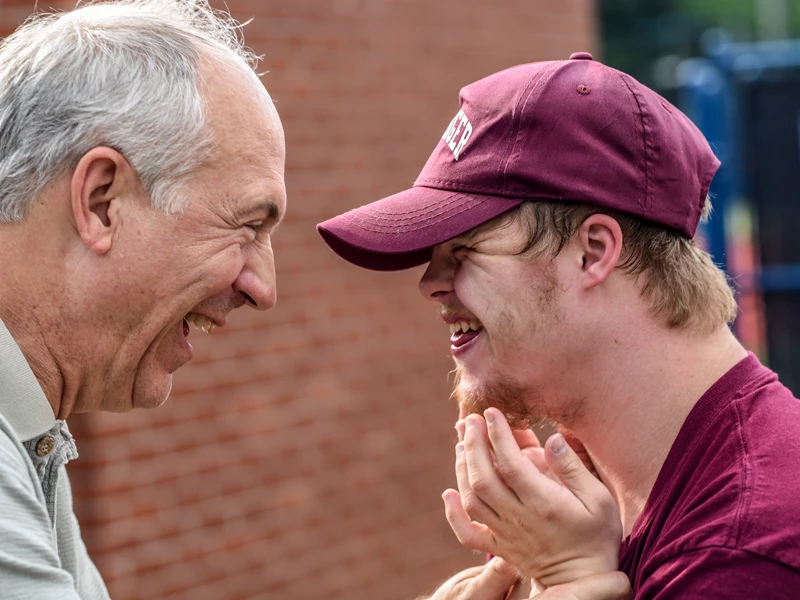 Older man with young man laughing with each other