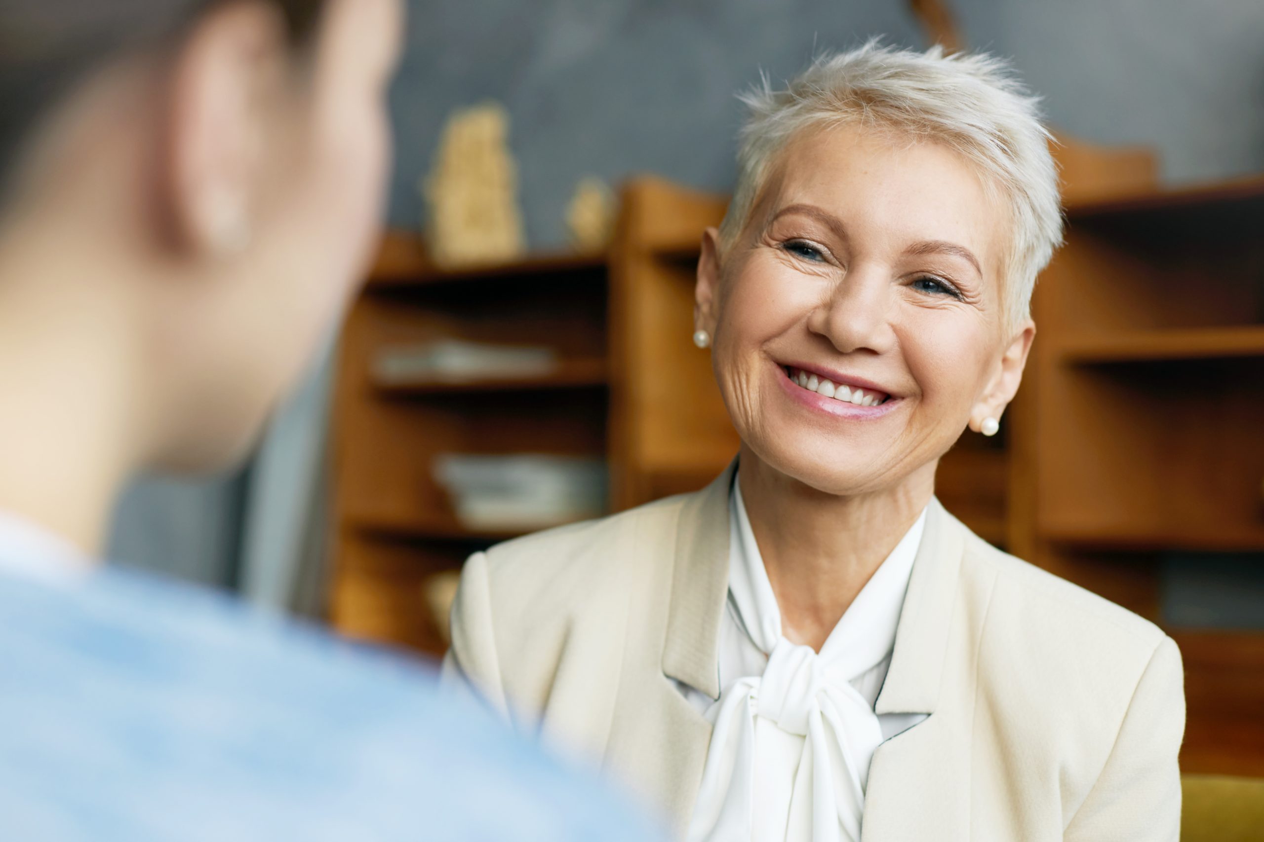 Portrait of short haired mature woman interviewing female job candidate, smiling